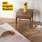Gelbes Katzenlaser-Spielzeug mit 360°-Drehung auf Holztisch, roter Laserpunkt auf Teppich.