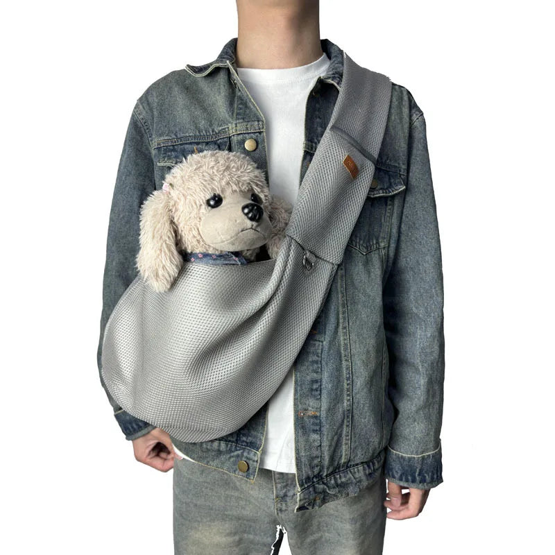 Person mit Jeansjacke trägt graue Hundetragetasche mit Plüschhund.