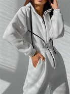 Damen-Overall in Weiß mit Reißverschluss und schwarzen Akzenten, ideal für Freizeitmode. Bequemes Design, perfekt für trendige Outfits.