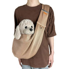 Person mit braunem T-Shirt trägt beige Hundetragetasche mit Plüschhund.