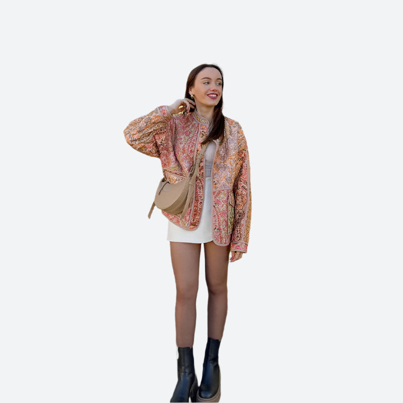 Frau in modischer Jacke und Stiefeln vor gelbem Haus. Streetstyle, Herbstmode, trendige Outfits, urbane Modefotografie.