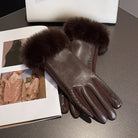 Damenlederhandschuhe mit Pelzbesatz auf Tisch, neben Modezeitschrift und weißer Tasche. Elegante Winteraccessoires, stilvoll und luxuriös.