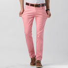 Herren Chinohose in Rosa, modern und stilvoll, ideal für Freizeit und Büro. Kombiniert mit Ledergürtel und braunen Schuhen. Perfekt für Frühling.