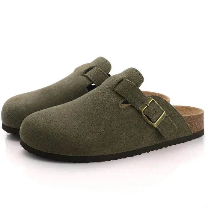 Grüne Wildleder-Clogs mit verstellbarer Schnalle und ergonomischer Korksohle. Bequeme Hausschuhe, ideal für Alltag und Freizeit.