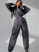 Damen-Jumpsuit in Dunkelgrau, lässig und bequem, ideal für Freizeit und Sport. Modischer Einteiler mit Kapuze und elastischem Bund.