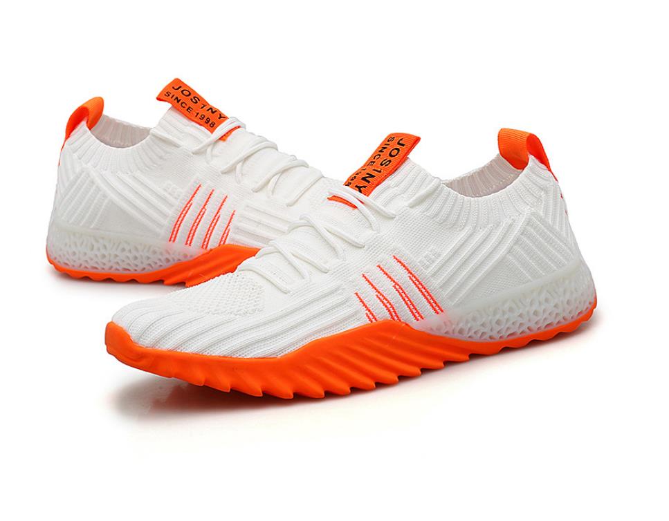 Weiße Sportschuhe mit orangefarbenen Akzenten, atmungsaktives Material, rutschfeste Sohle.