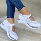 Damen-Sneaker in Weiß mit Klettverschluss, atmungsaktivem Mesh-Obermaterial und bequemer Sohle. Perfekt für Freizeit und Sport.