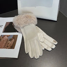 Elegante Damenhandschuhe aus weißem Leder mit Kunstpelzbesatz, ideal für Wintermode. Perfekt kombiniert mit stilvollen Accessoires.