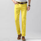 Herrenmode: Gelbe Chinohose aus Baumwolle, kombiniert mit braunem Ledergürtel und Schuhen. Stilvoll, modern, ideal für Freizeit und Büro.