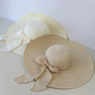 Zwei elegante Damen-Strohhüte mit breiter Krempe und Schleife, ideal für Sommer und Outdoor. Perfekt faltbar und stilvoll für modische Frauen.
