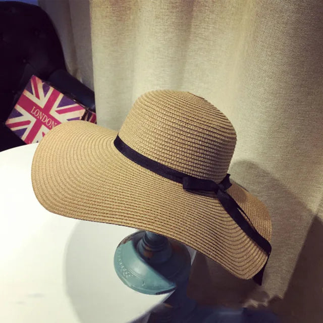 Damen-Strohhut mit breiter Krempe und schwarzer Schleife, ideal für Sommer und Outdoor. Faltbar, stilvoll und praktisch für Reisen.