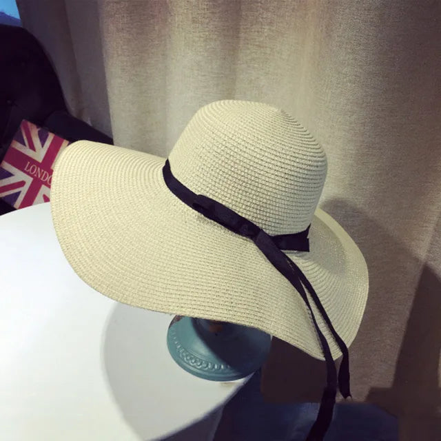 Breiter Strohhut für Damen mit schwarzem Band, ideal für Sommer und Strand. Faltbar, stilvoll und praktisch für Outdoor-Aktivitäten.