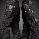 Taktische Cargohose, schwarz, Camouflage-Muster, mit Taschen und Reißverschlüssen, Outdoor-Bekleidung.