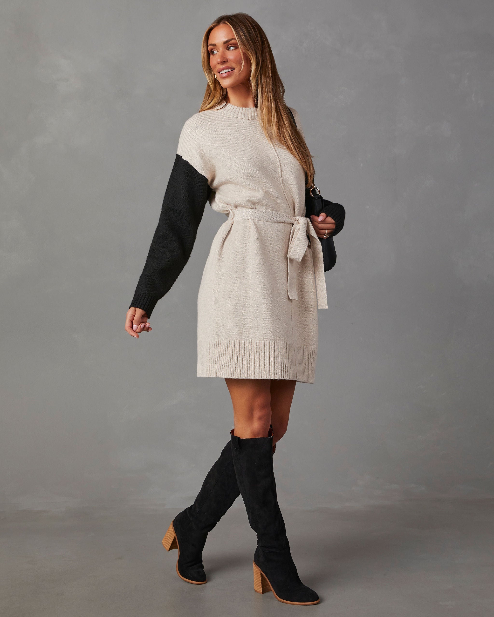 Damen Strickkleid in Elfenbein und Schwarz, langärmelig, mit Gürtel. Perfekt für Herbstmode, kombiniert mit schwarzen Stiefeln. Eleganter Look.