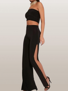 Schwarze Damenhose mit hohem Schlitz, elegantem Design und figurbetontem Schnitt. Perfekt für Partys und Abendveranstaltungen.