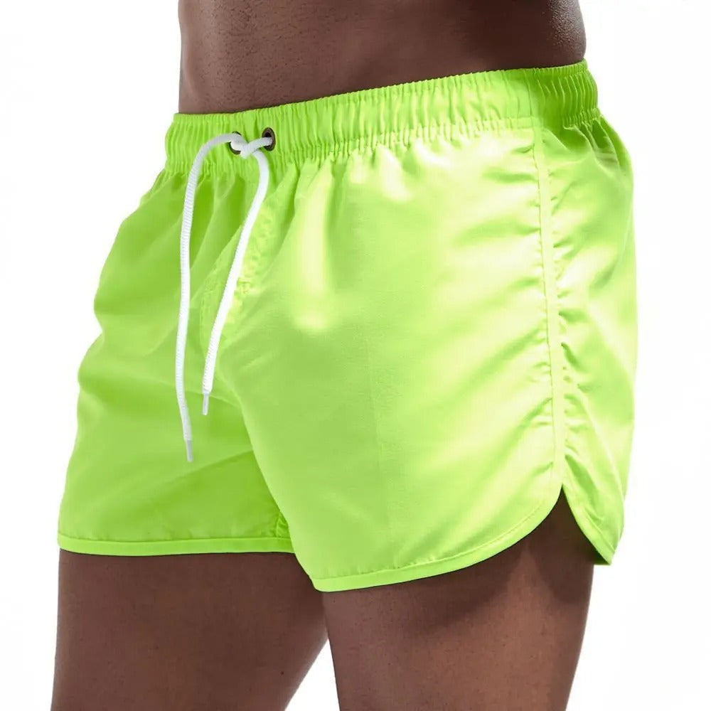Neon-grüne Herren-Badeshorts, elastischer Bund, Kordelzug, Sommermode, Strandbekleidung.