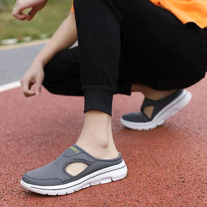 Grauer Sportschuh mit atmungsaktivem Mesh-Obermaterial und weißer Sohle, ideal für Laufen und Freizeit. Bequeme Passform, modisches Design.