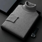 Grauer Rollkragenpullover aus feiner Wolle, elegant gefaltet in schwarzer Geschenkbox. Perfekt für stilvolle Herrenmode und Winterbekleidung.
