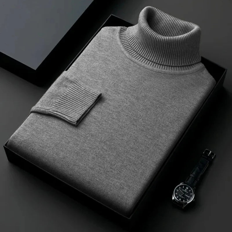 Grauer Rollkragenpullover aus feiner Wolle, elegant gefaltet in schwarzer Geschenkbox. Perfekt für stilvolle Herrenmode und Winterbekleidung.