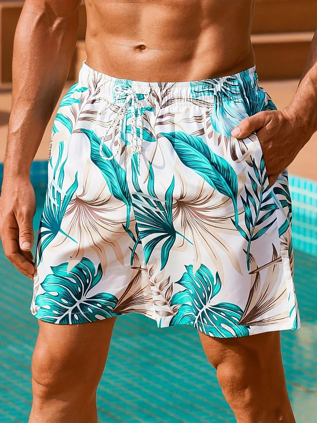 Herren-Badeshorts mit tropischem Blattmuster, weiß-türkis, Sommermode, Strandbekleidung.