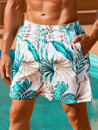 Herren-Badeshorts mit tropischem Blattmuster, weiß-türkis, Sommermode, Strandbekleidung.