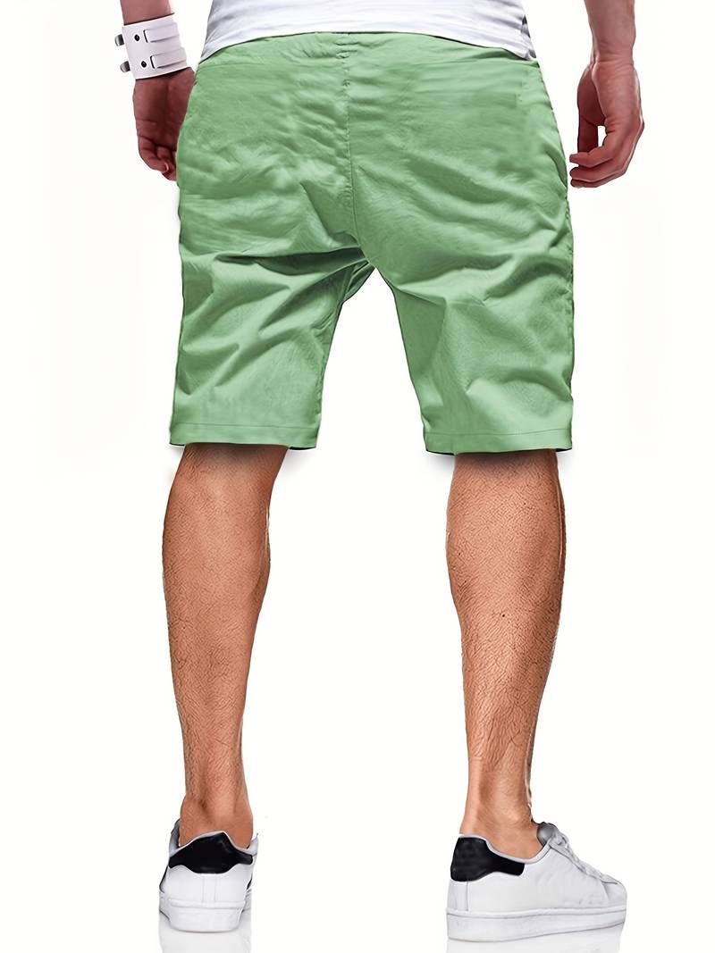 Mann in grüner Chino-Shorts, Rückansicht, lässige Sommermode, weiße Sneaker.