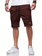 Mann trägt braune Shorts, weißes T-Shirt und weiße Sneaker, lässiger Sommerlook.
