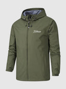 Wasserdichte grüne Herrenjacke mit Kapuze, Reißverschluss und "Titleist"-Logo. Ideal für Outdoor-Aktivitäten und Golf. Robustes, wetterfestes Design.