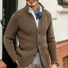 Eleganter Herren-Strickblazer in Braun, kombiniert mit weißem Hemd und blauem Halstuch. Perfekt für stilvolle Herbst- und Wintermode.