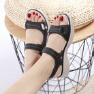 Schwarze Damen-Sandalen mit Klettverschluss, bequeme Sohle, ideal für Sommermode. Perfekt für Freizeit und Outdoor-Aktivitäten.
