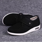 Schwarze orthopädische Schuhe mit Klettverschluss, atmungsaktivem Mesh-Obermaterial und weißer Sohle, ideal für Komfort und Fußgesundheit.