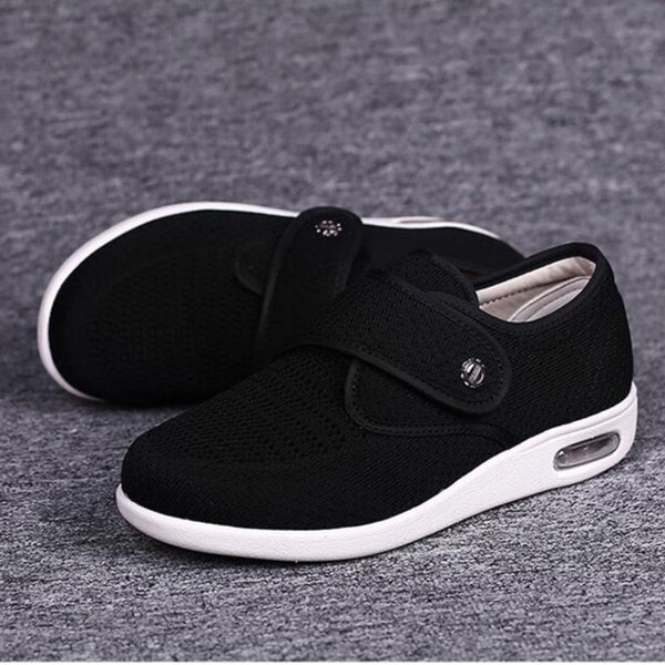 Schwarze orthopädische Schuhe mit Klettverschluss, atmungsaktivem Mesh-Obermaterial und weißer Sohle, ideal für Komfort und Fußgesundheit.