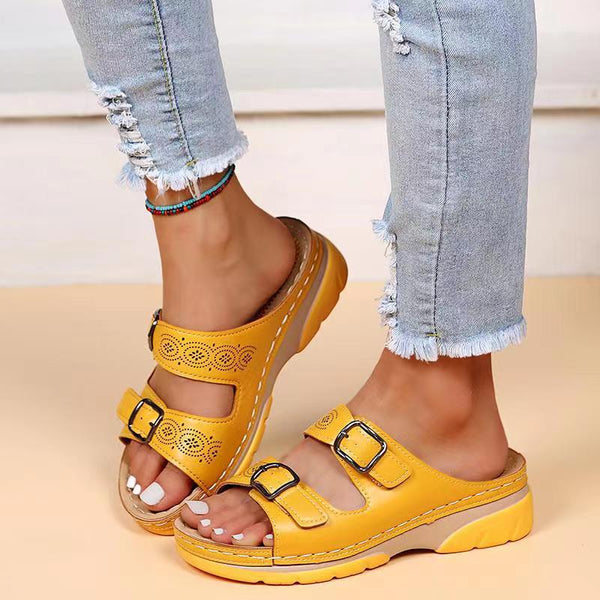 Gelbe Sandalen mit Keilabsatz und Schnallen, getragen mit zerrissenen Jeans. Modische Sommerschuhe, bequem und stilvoll für Damen.