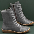 Graue Damenstiefel aus Leder mit seitlichem Reißverschluss und Schnürung, rutschfeste Sohle. Modische, bequeme Herbst- und Winterstiefel.