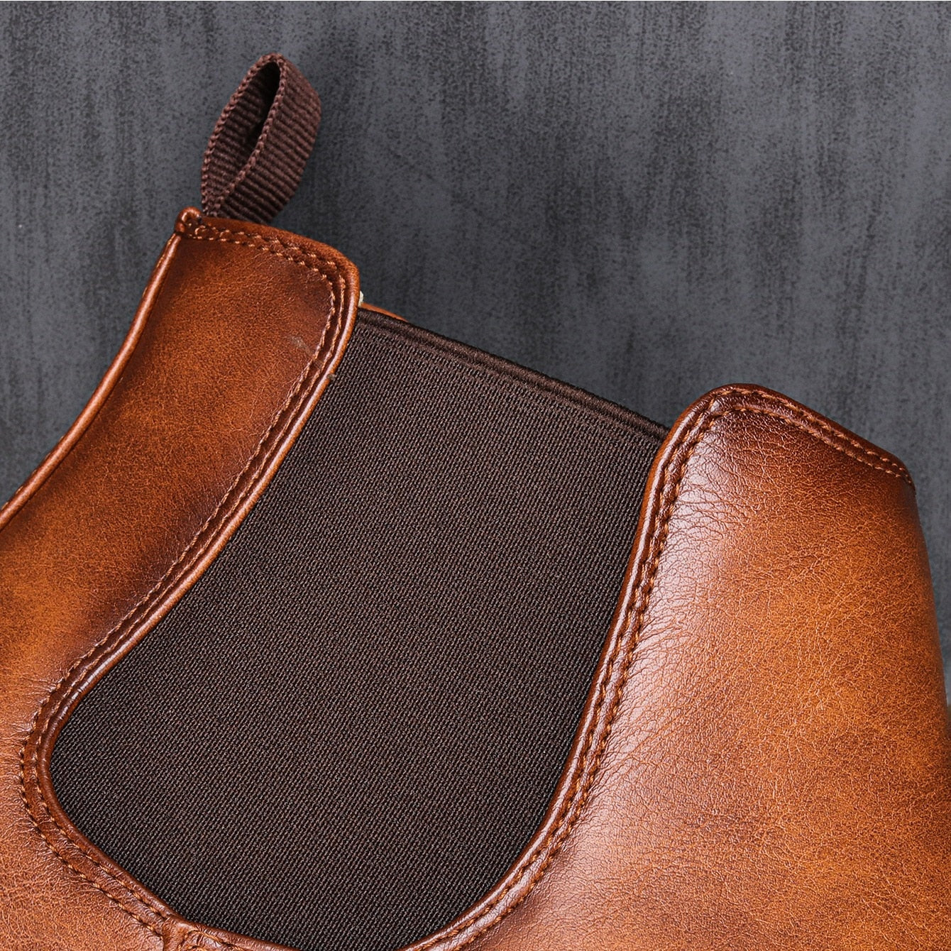 Nahaufnahme eines braunen Chelsea Boots aus Leder mit elastischem Einsatz. Stilvolle Herrenschuhe, ideal für Herbstmode und elegante Outfits.