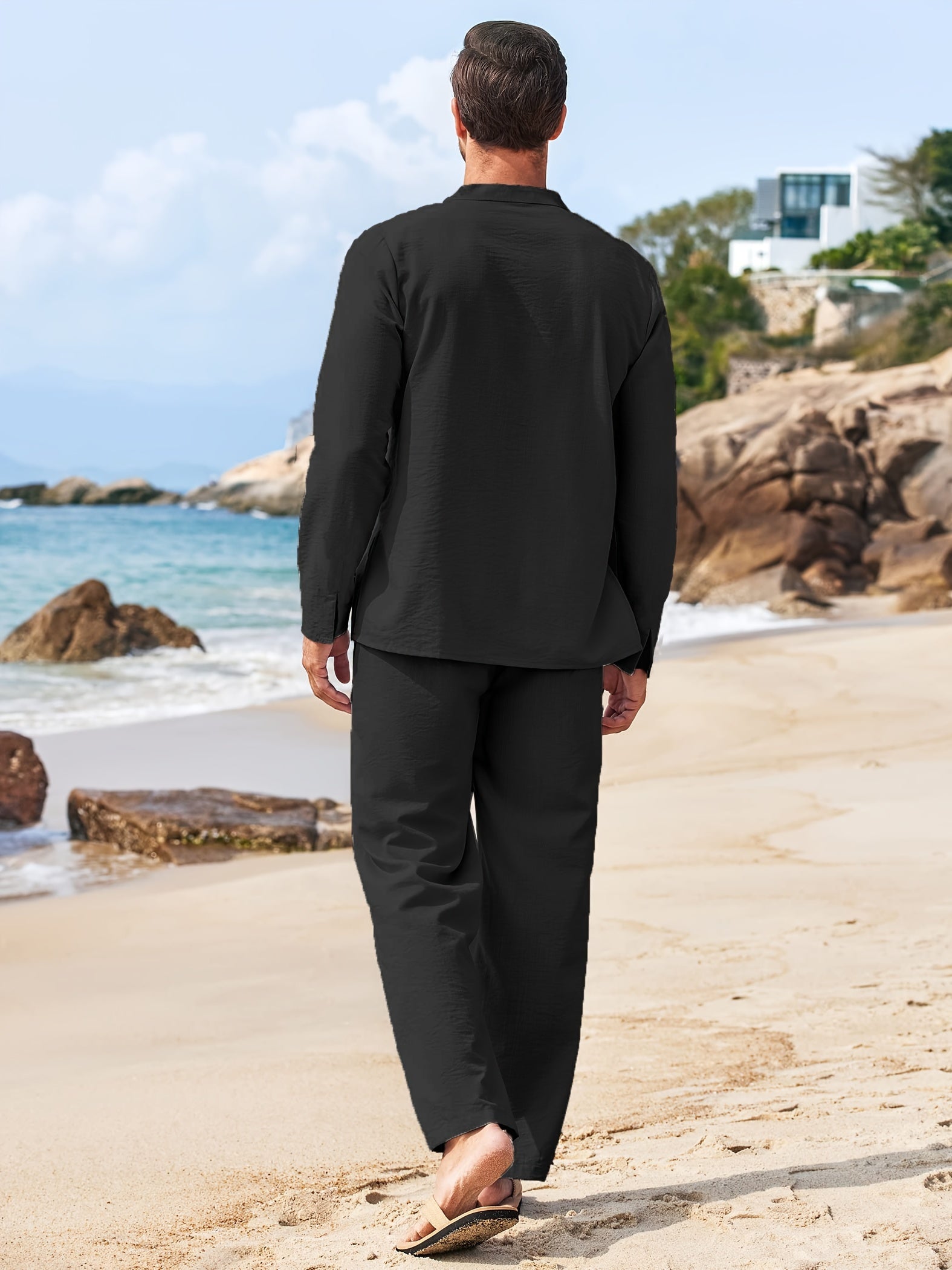 Mann in schwarzem Leinenanzug am Strand, Sommermode, lässiger Stil, Herrenbekleidung, Strandspaziergang, entspannte Atmosphäre.