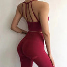Rotes Sportset mit dekorativen Rückenträgern, nahtloser Leggings und Top. Perfekt für Fitness, Yoga und Sport. Bequem und stilvoll.