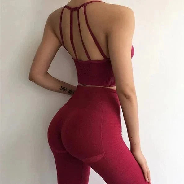 Rotes Sportset mit dekorativen Rückenträgern, nahtloser Leggings und Top. Perfekt für Fitness, Yoga und Sport. Bequem und stilvoll.