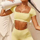 Damen-Sportset in Gelb mit dekorativen Streifen, bestehend aus Crop-Top und Leggings. Ideal für Yoga und Fitness. Atmungsaktiv und stylisch.