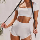 Graues Sportset mit dekorativen Streifen, bestehend aus kurzem Top und Shorts. Perfekt für Fitness, Yoga und Freizeit. Hochwertige Sportbekleidung.
