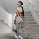Graues Sportset für Damen, bestehend aus kurzem Oberteil und Leggings. Perfekt für Fitness und Freizeit. Trendige Sportmode, bequem und stilvoll.