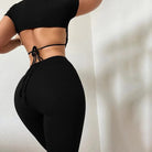 Schwarzes Sportset für Damen, bestehend aus kurzem Oberteil und Leggings. Ideal für Fitness, Yoga und Freizeit. Bequem und stilvoll.