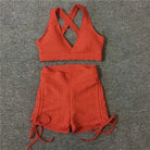 Rotes Sportset mit kurzen Shorts und überkreuztem Top, ideal für Fitness und Yoga. Atmungsaktives Material, modisch und bequem.