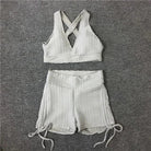 Weißes Sportset für Damen, bestehend aus kurzem Top und Shorts mit Kordelzug. Ideal für Fitness, Yoga und Freizeit. Hochwertige Sportbekleidung.