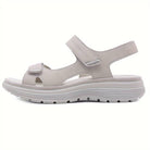 Beige Damen-Sandale mit Klettverschluss, ergonomischer Sohle und rutschfestem Profil. Ideal für Komfort und Stil im Sommer.