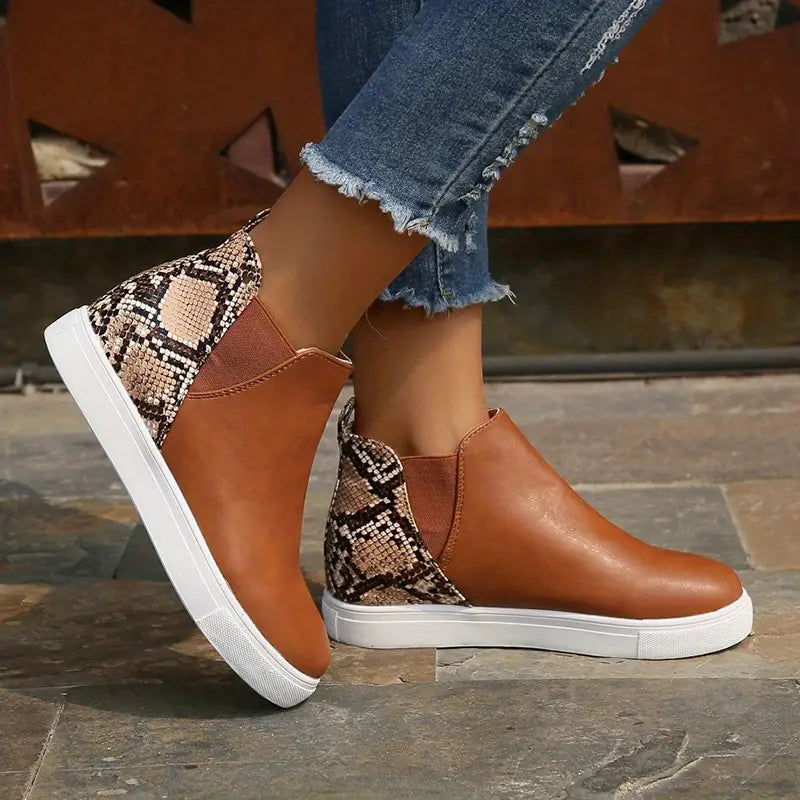 Damen-Sneaker mit Schlangenmuster und braunem Leder, kombiniert mit weißer Sohle. Modische Freizeitschuhe, ideal für den urbanen Look.
