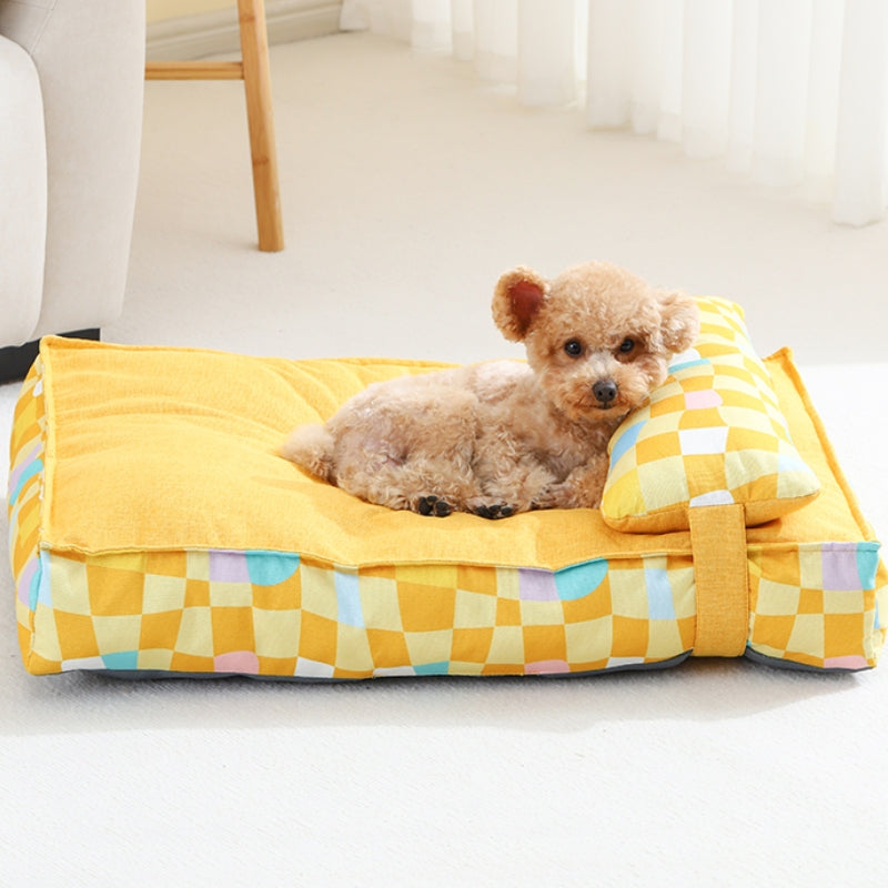 Kleiner Hund auf gelbem orthopädischen Hundebett mit Karomuster, bequem und stilvoll.