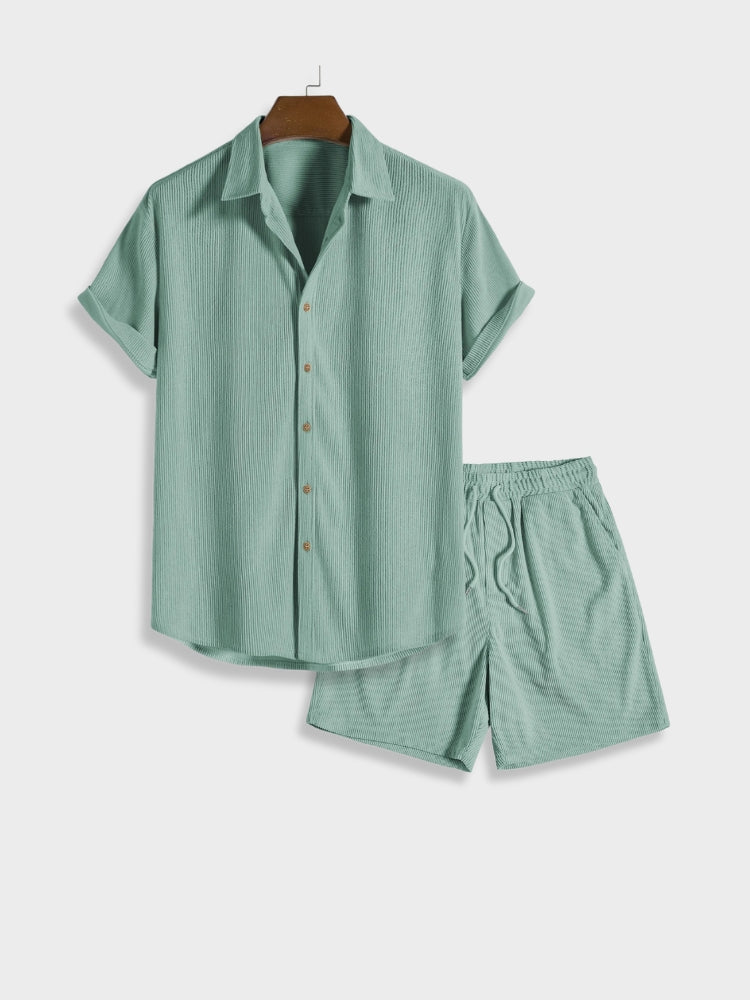 Grünes Herren-Set aus kurzärmeligem Hemd und Shorts, ideal für Sommermode. Leichtes Material, lässiger Stil, perfekt für Freizeitkleidung.