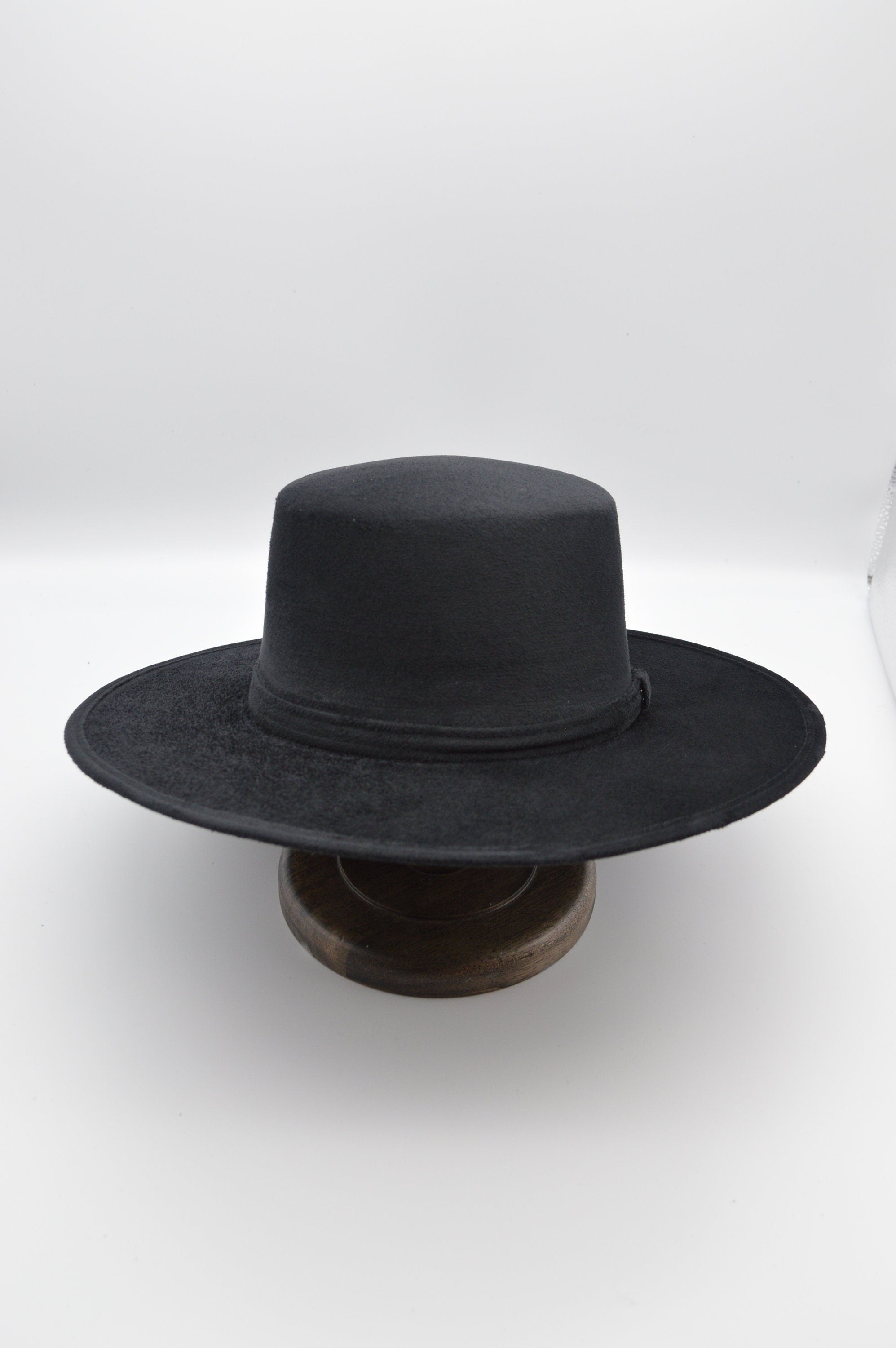 Schwarzer Filzhut mit breiter Krempe auf Holzständer, klassisches Design, ideal für Herrenmode, Vintage-Stil, zeitloser Look.