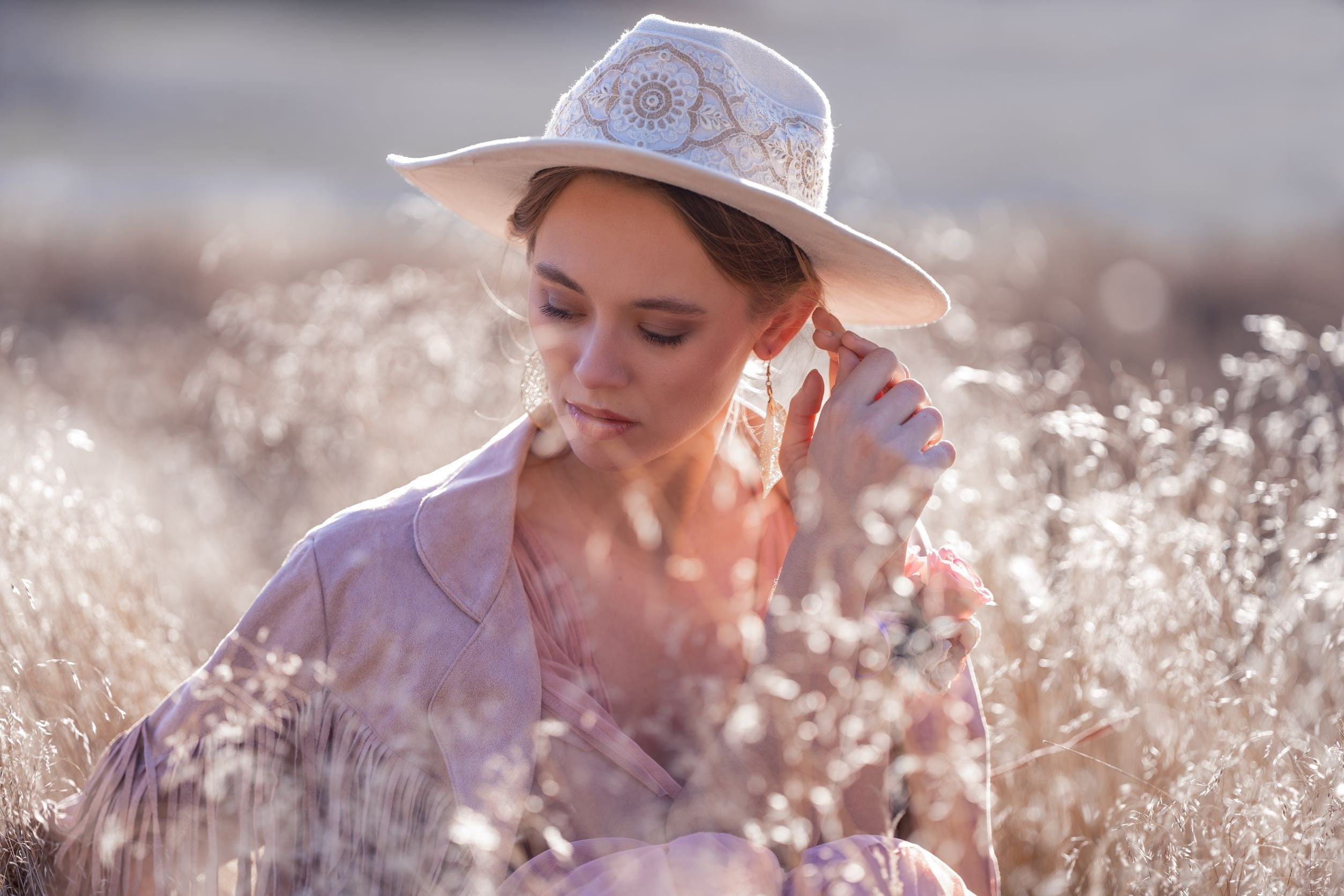 Frau mit elegantem, besticktem Hut in natürlicher Umgebung. Mode, Accessoires, Damenhut, Outdoor-Fotografie, stilvoll, feminin.
